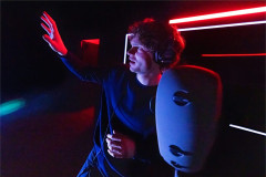 Lucas Iverson under red light in A Ghost in Your Ear. Photo by Matthew Murphy