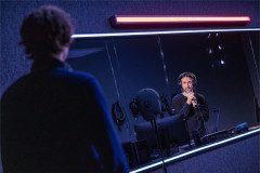 Lucas Iverson faces Owen Campbell through the booth window in A Ghost in Your Ear. Photo by Matthew Murphy