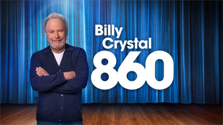 Billy Crystal stands with folded arms in front of a blue stage curtain beside the title 860