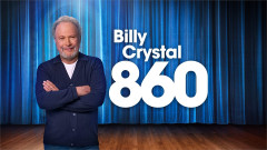 Billy Crystal stands with folded arms in front of a blue stage curtain beside the title 860