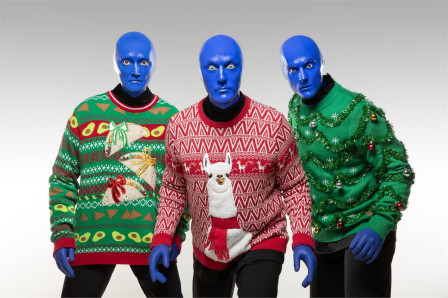 Three Blue Man Group performers in holiday sweaters