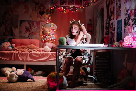 Christopher Dylan White as Target, in cow-print cosplay, in a bedroom full of plush toys in Degenerates at Playwrights Horizons