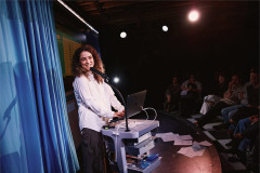 Rachel Kaly at a lectern set on a medical cart in Hospital Hour at The Culture Club. Photo by Emilio Madrid