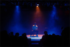 Drew Michael seated on stage in Love Me at SoHo Playhouse. Photo by Curtis Brown