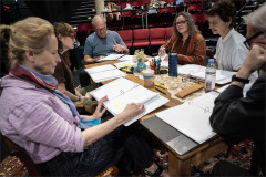 The company of We'll See around the table in rehearsal at The Public Theater. Photo by Joan Marcus