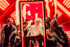 The company crowds around a glass frame under red light in The Who’s Tommy. Photo by Evan Zimmerman for MurphyMade