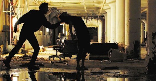 Two dancers silhouetted on an abandoned factory floor in Bridgman | Packer Dance’s Ghost Factory