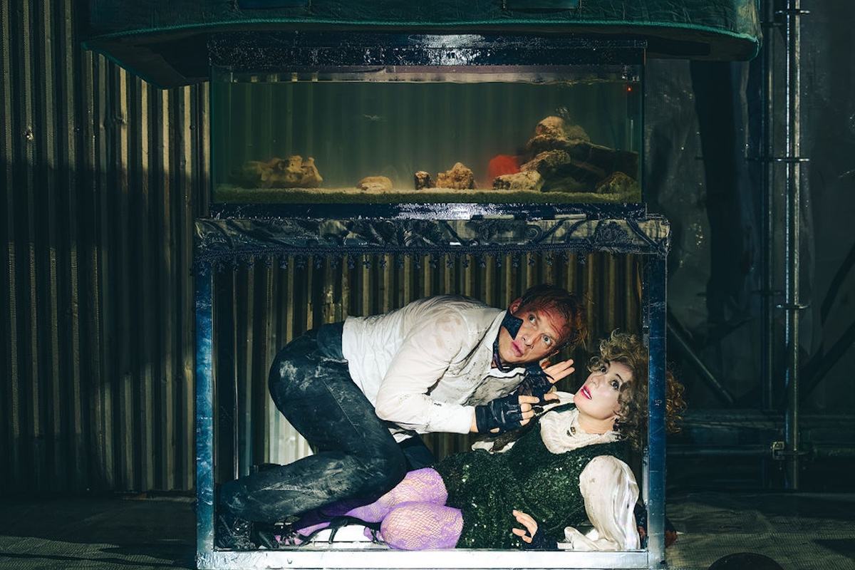 Andrey Burkovskiy and Chulpan Khamatova crouched beneath the fish tank in Delirium at the Space at Irondale. Photo by Austin Ruffer Andrey Burkovskiy and Chulpan Khamatova crouched beneath the fish tank in Delirium at the Space at Irondale. Photo by Austin Ruffer