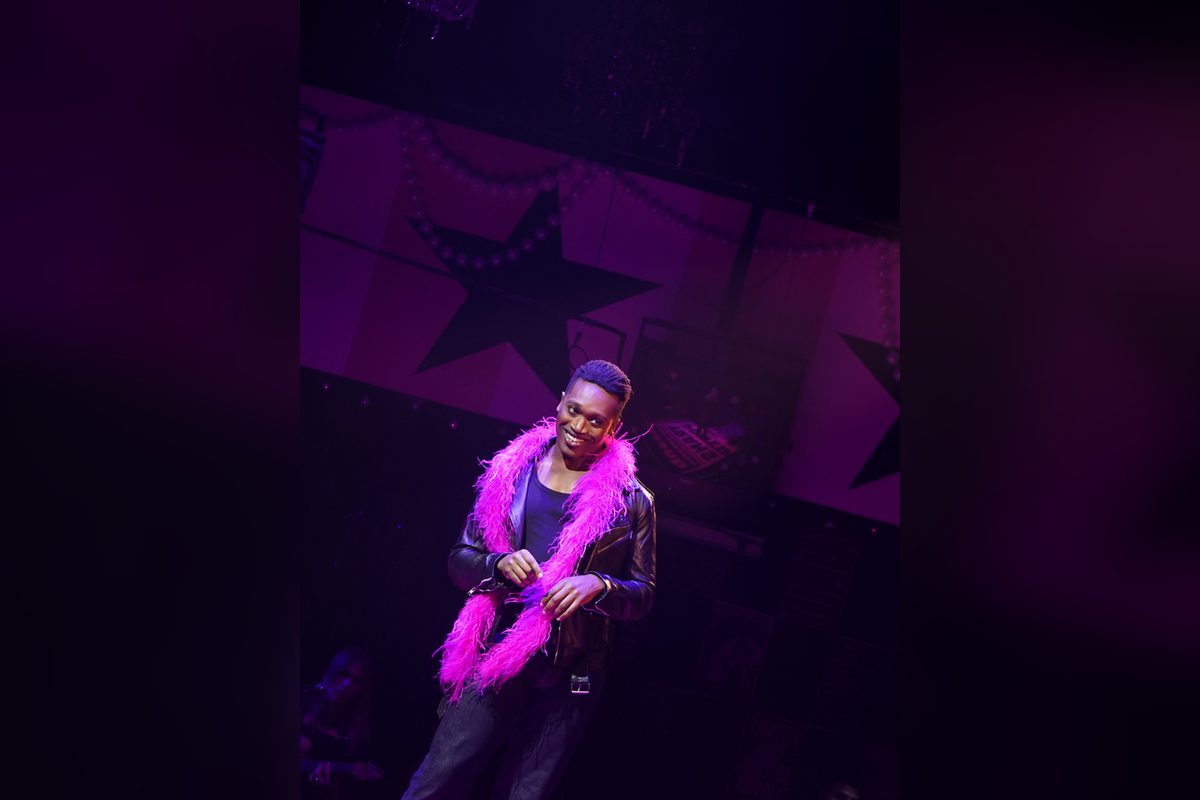 Ato Blankson-Wood as Terence Alan Smith/Joan Jett Blakk in MS. BLAKK FOR PRESIDENT at Vineyard Theatre, in a leather jacket and pink feather boa. Photo by Carol Rosegg