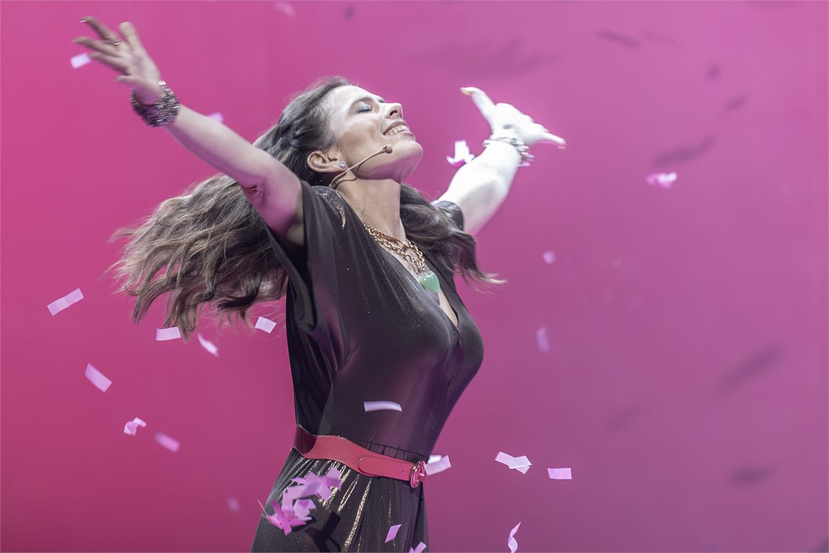 Hayley Atwell as Beatrice in Much Ado About Nothing in London, arms raised under falling pink confetti. Photo by Marc Brenner