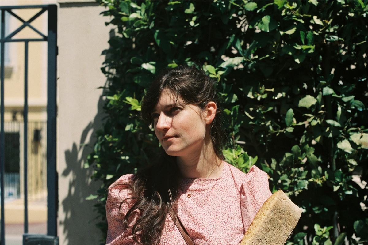 Liba Vaynberg, writer of The Blue Parts, photographed outdoors against a sunlit hedge